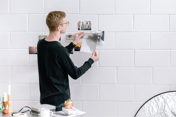 Man puts photos on the wall